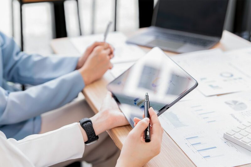 Zwei Personen, die vor einem Tablet sitzen und Statistiken zum Energieverbrauch angucken.