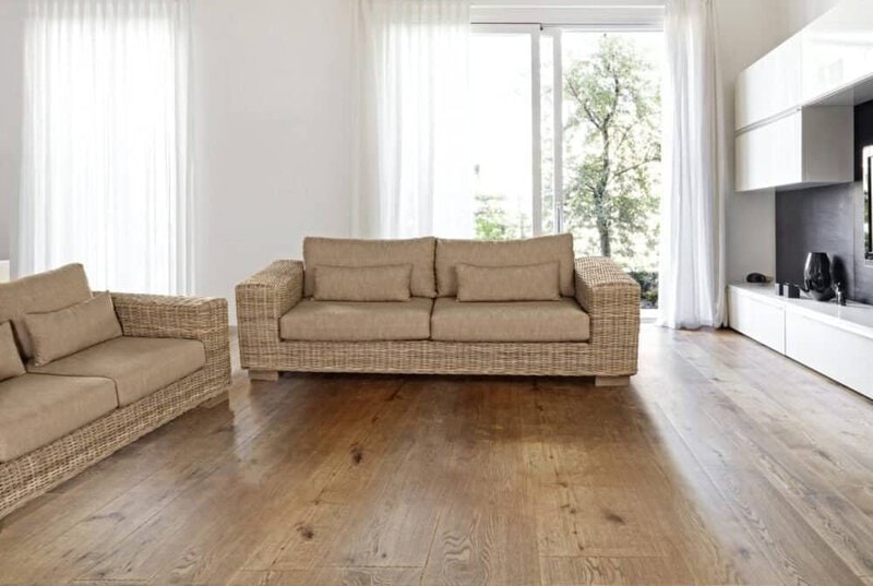 Divani in rattan beige con cuscini, soggiorno moderno con grande finestra e arredi eleganti.