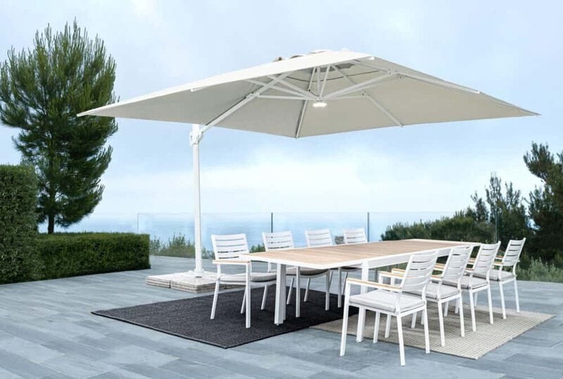 Ombrellone bianco e tavolo da esterno con sedie, arredamento per giardini e spazi all'aperto di design.
