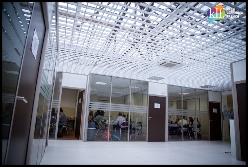 Moderne Klassenräume der Sprachschule Lyon Bleu International mit Glaswänden und aktivem Unterricht.