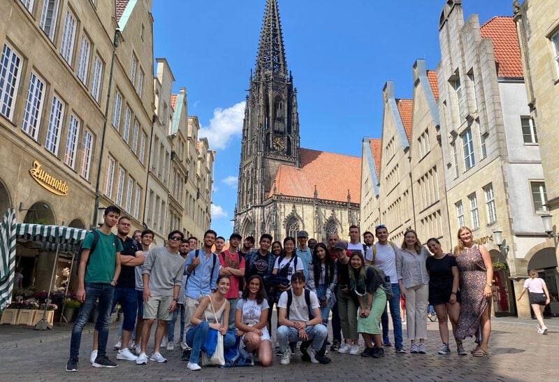 Internationale Studierendengruppe vor der Lambertikirche in der Altstadt von Münster