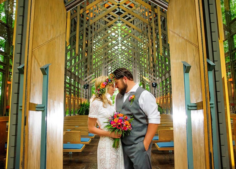 Couple Standing Outside of Chapel Holding Flowers