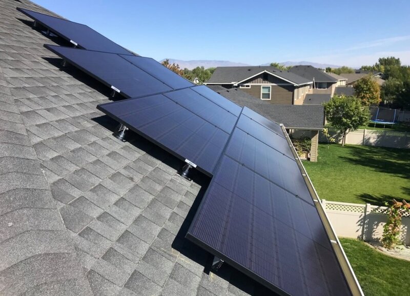 Rooftop in Boise with solar panels on it and neighborhood plus foothills in the distance