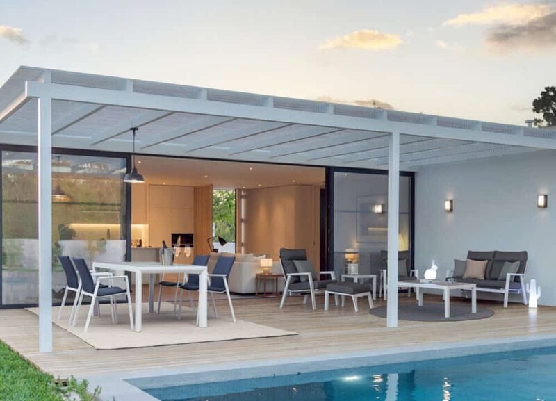 Elenco di zona relax all'aperto con mobili eleganti e piscina.