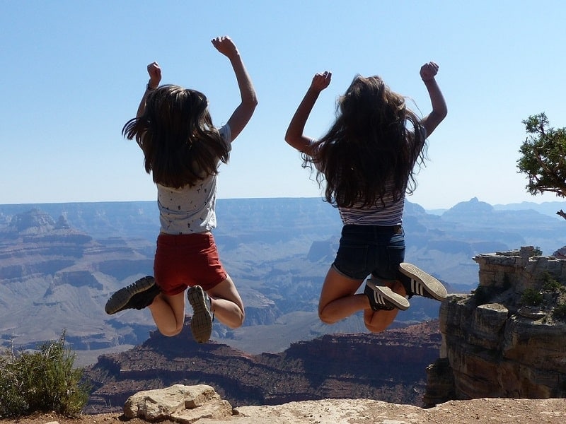 two girls jumping near the Grand Canyon 