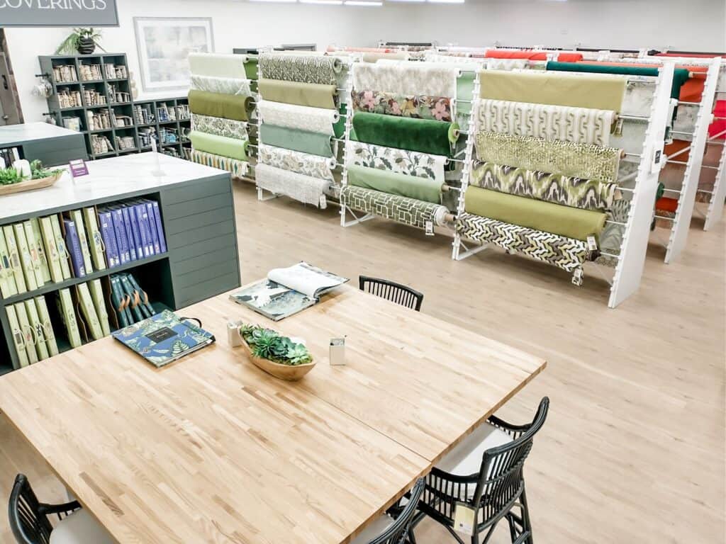 Colorful fabric rolls displayed on modern racks inside a fabric or home decor store.