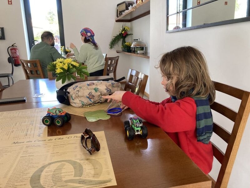 Kid playing at restaurant with a couple of toys.