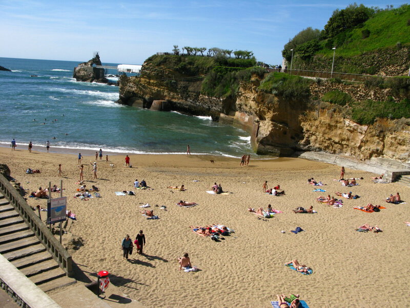 Sonniger Strand in Biarritz mit Blick auf das Meer und die Felsenlandschaft.