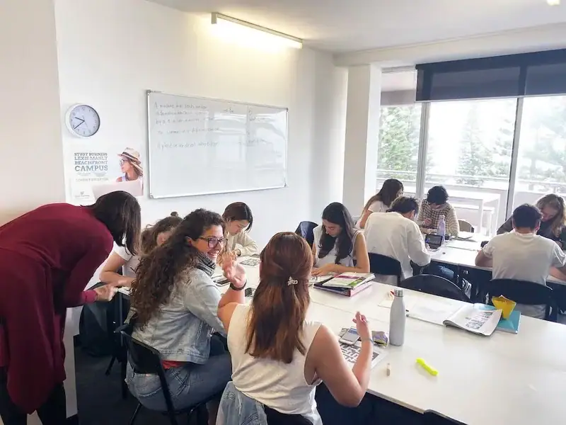 Sprachschüler in einem modernen Klassenzimmer mit Lehrerunterstützung.