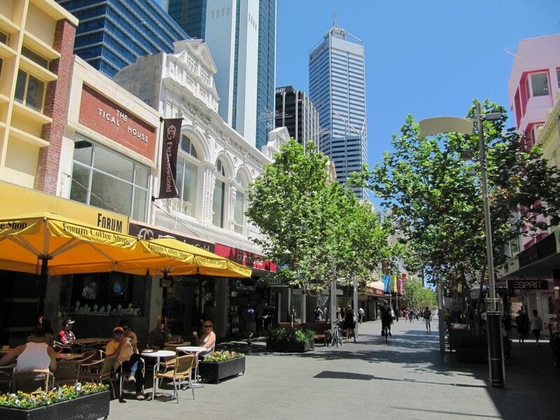 Fußgängerzone in Perth mit Cafés, Geschäften und modernen Hochhäusern im Hintergrund.