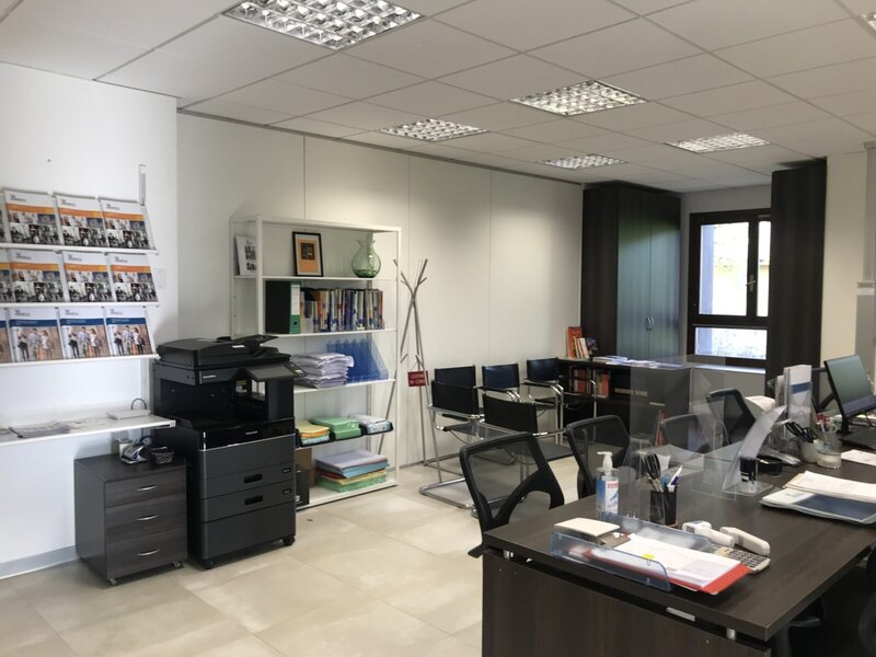 Modernes Büro mit Schreibtischen, Wartebereich und Druckstation.