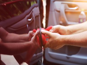 Person using a suction cup to remove dents without damaging paint.
