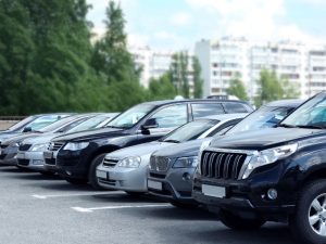 Various cars parked outdoors, showing the types of car dents that can occur in parking lots.