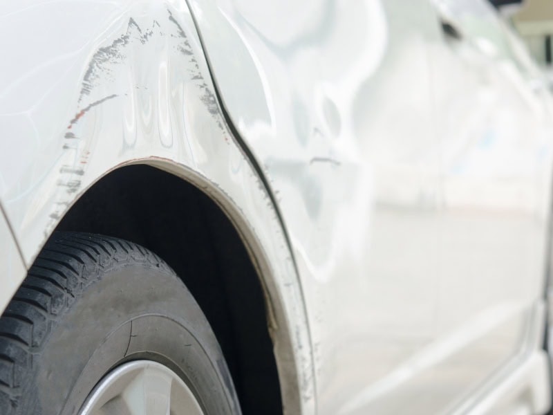A close-up of a large car dent, illustrating the process of removing small dents from a ca