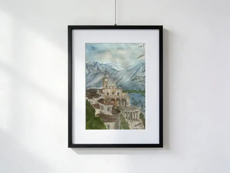 Acquerello della Chiesa Madonna del Sasso sopra Locarno, con montagne e Lago Maggiore sullo sfondo, inserito in un passepartout bianco e in una cornice nera; dimensioni esterne 30 × 40 cm.