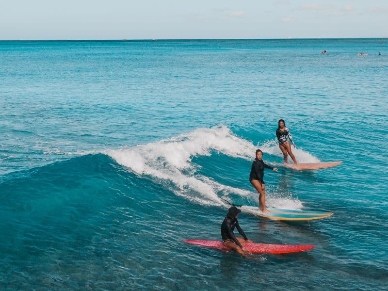 three women on surfboards doing Puerto Escondido surfing lessons in Mexico