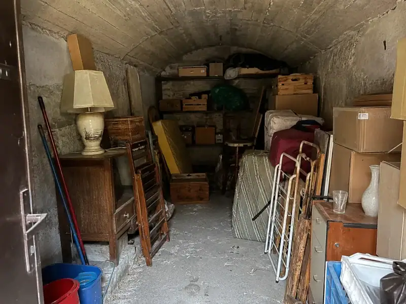 Cave sombre encombrée avant enlèvement d’objets stockés