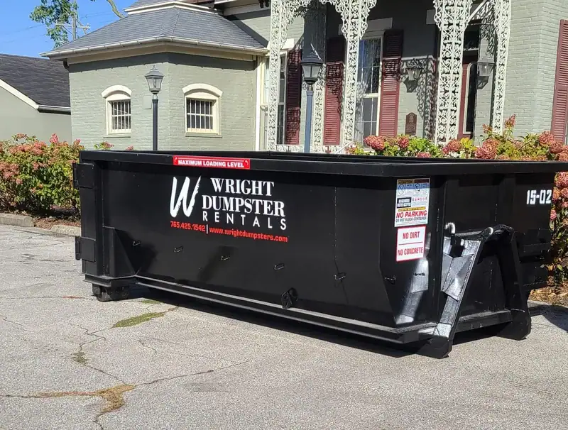 An image of black dumpster outside the house