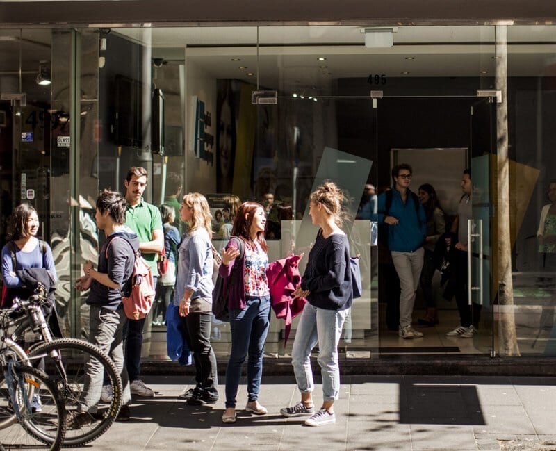 Internationale Sprachschüler vor einer Sprachschule im Gespräch.