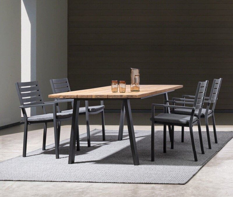 Elegante tavolo da pranzo in legno con sedie nere, ideale per ambienti moderni e raffinati.