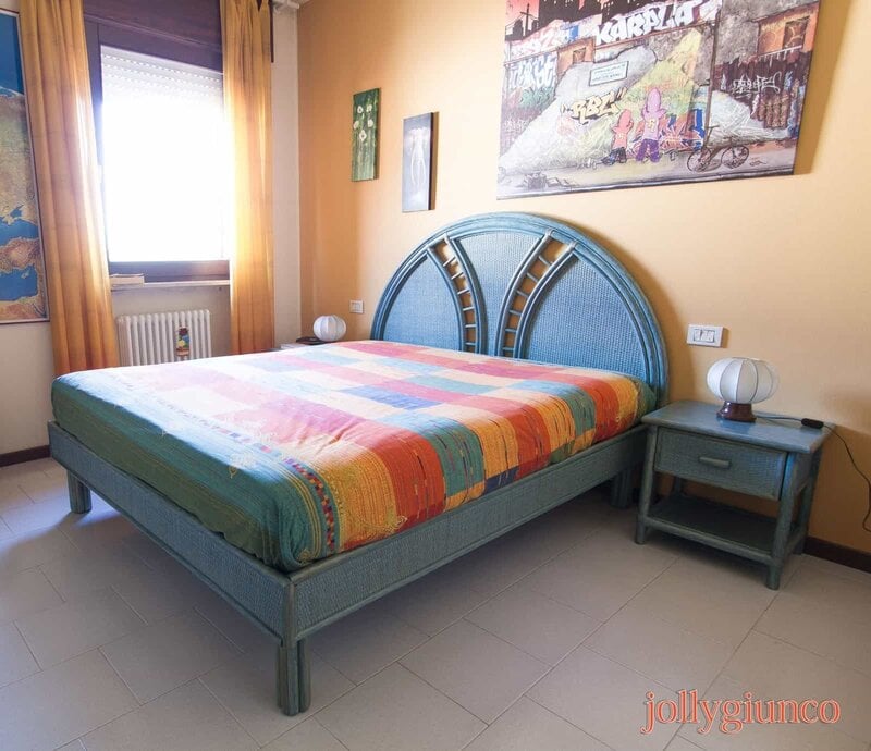 Letta singola con letto colorato e arredi di design in un ambiente accogliente e luminoso.