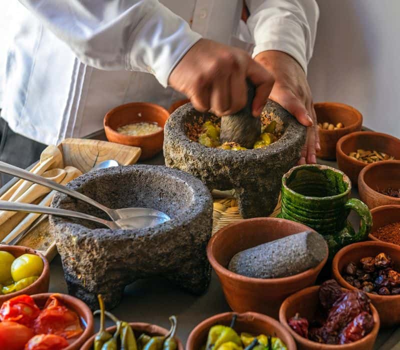 man preparing salsas in molcajete at best huatulco tours