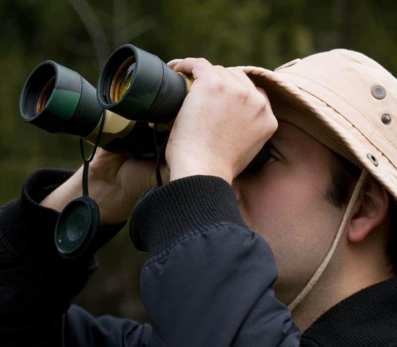 man bird-watching with binoculars in oaxaca mexico