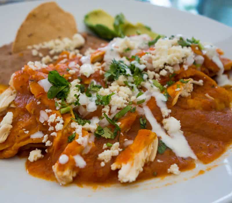 traditional mexican breakfast dish called chilaquiles, amde with chips, salsa and eggs
