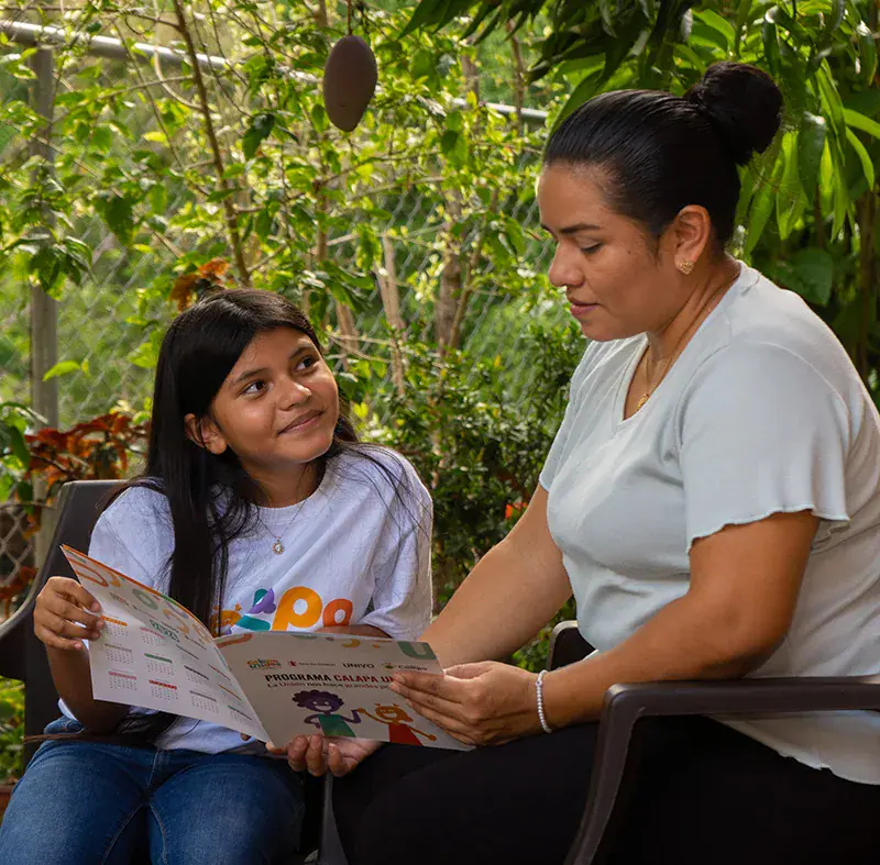 Nahomy, 11, and her mom, Esmeralda, read some information about Child Safeguarding, a promotional material that includes the Calapa Unidos