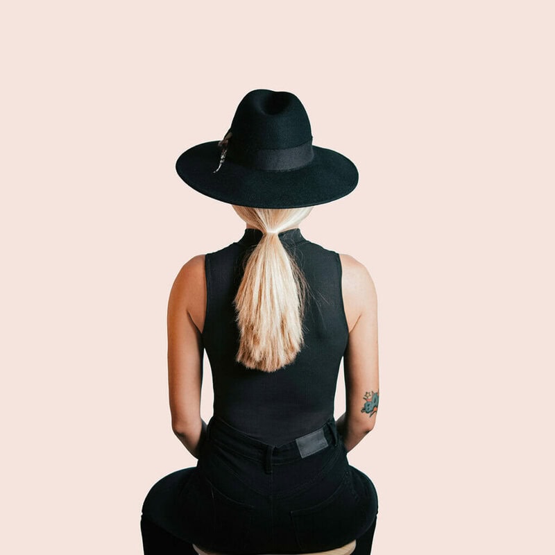 stylish woman in black sitting with her back to us