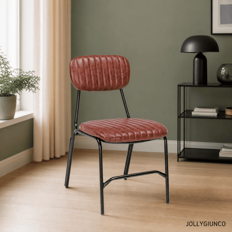 Red upholstered chair with black metal legs in a modern living space, green wall and black table lamp nearby
