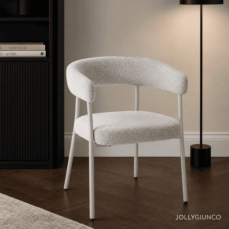 Modern interior with a light gray textured chair, a dark bookshelf on the left, and a tall black floor lamp on the right.