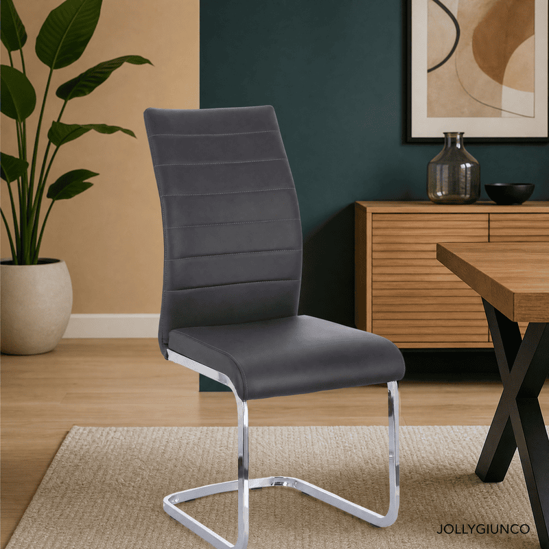 Gray upholstered office chair with a chrome sled base in a modern workspace, with a plant and wood cabinet in the background.