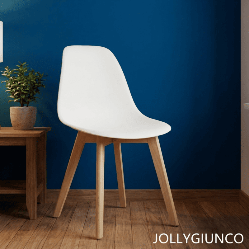 White molded chair with pale wooden legs beside a small wooden table and potted plant against a dark blue wall.