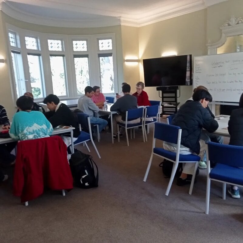 Gruppenarbeit in einem Lernraum mit Studierenden und Lehrenden.