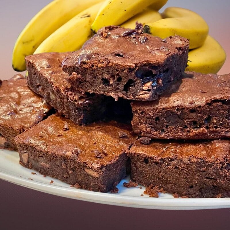 “Brownie de banana e cacau cortado em quadrados em prato de sobremesa