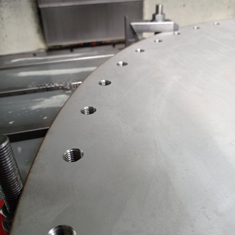 Detalle de chapa metálica curvada con taladros mecanizados