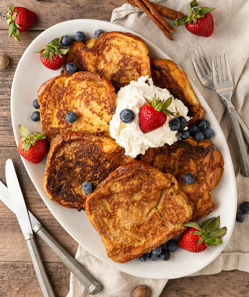 plate of french toast with berries and whipped cream