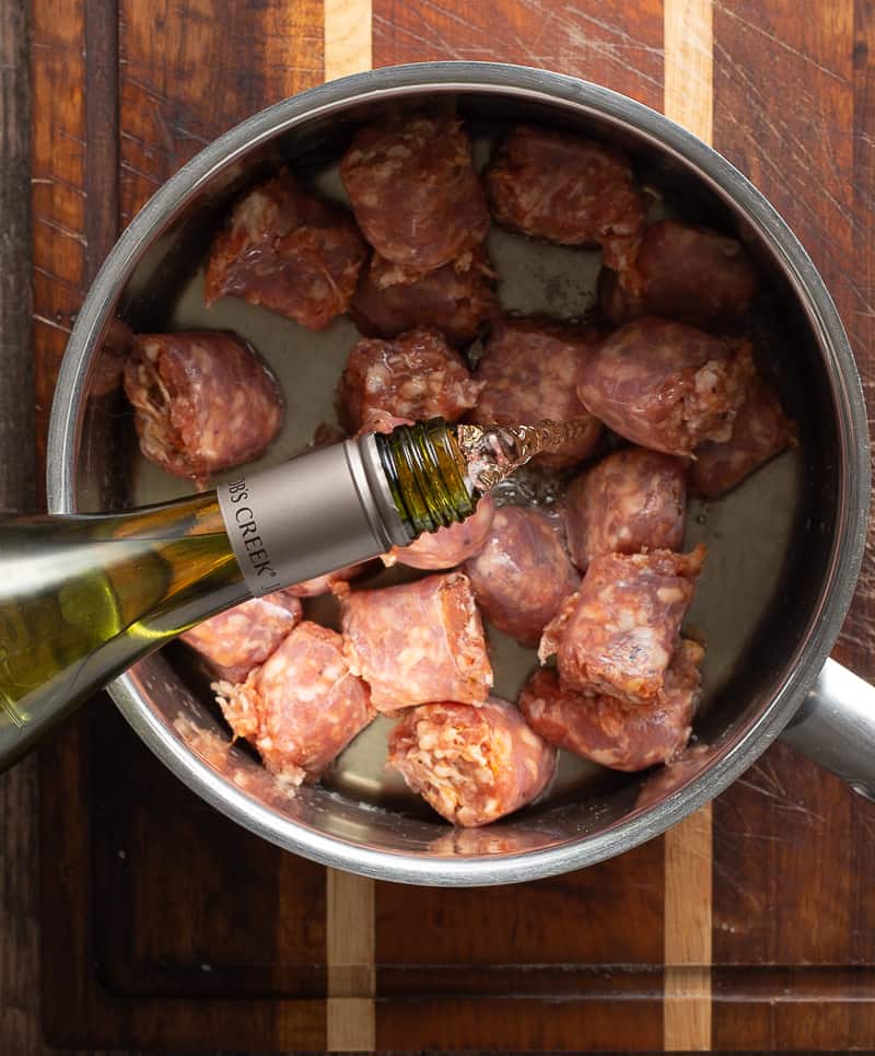 adding wine to sausage