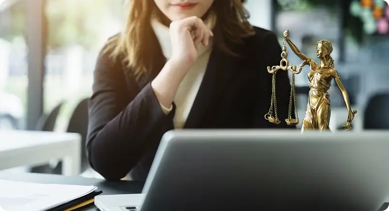 A woman sits in front of a laptop
