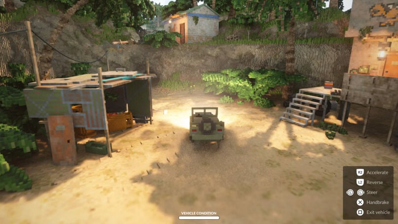 screenshot showing a green army jeep being driven across a sandy beach. There are some raised shacks each side and a cliff top with a grey and blue building above.