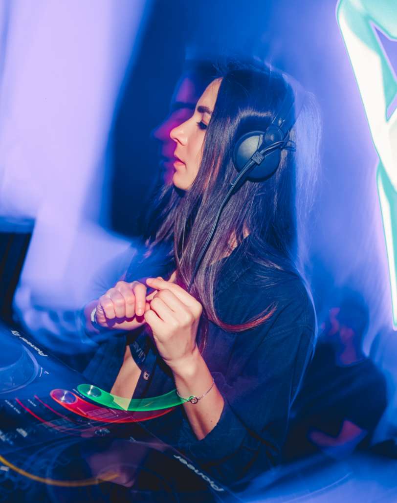 Female DJ performing live at P7 Arena, Media One Hotel, surrounded by vibrant neon lights and an electrifying club atmosphere. Female DJ performing live at P7 Arena, Media One Hotel, surrounded by vibrant neon lights and an electrifying club atmosphere.