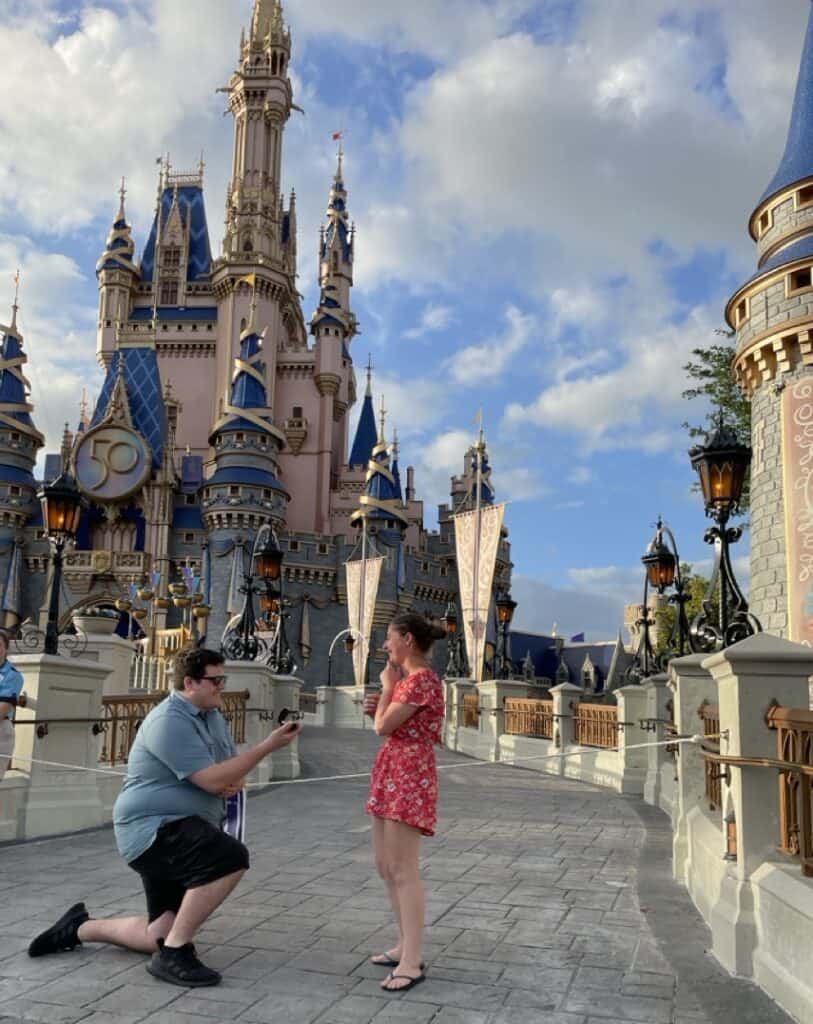 Getting engaged at Disney Castle, magical vacation moment at 407 Vacations.