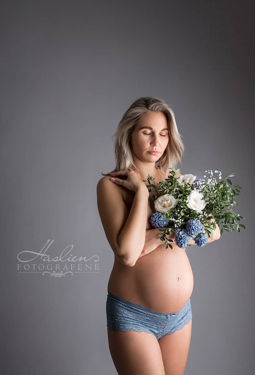 Elegant gravidfotografi av gravid kvinne med blomsterekke, som viser skjønnheten og styrken til mor i svangerskapet. Perfekt for gravidfotuavbildning, mødrefoto og prenatal fotografering.