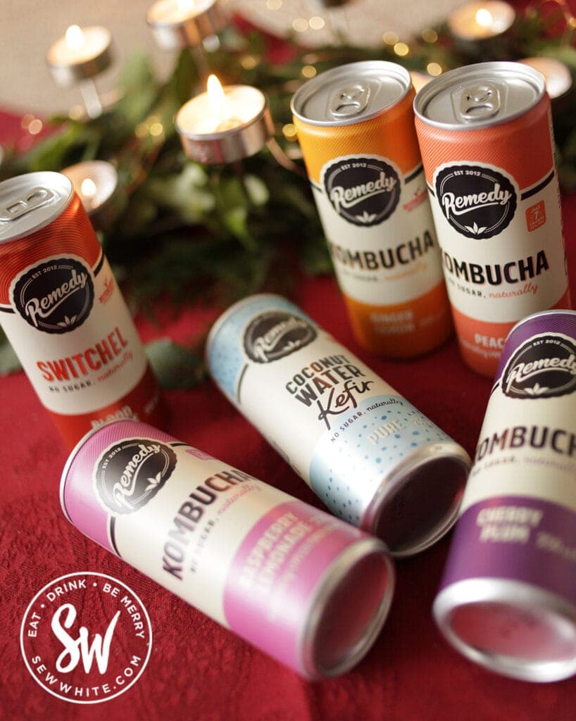 Remedy Kombucha raimbow cans on a red table cloth with candle