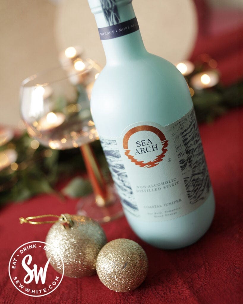 Sea Arch non alcoholic distilled spirit in light blue bottle  on a red table cloth in teh drink gift guide 2021