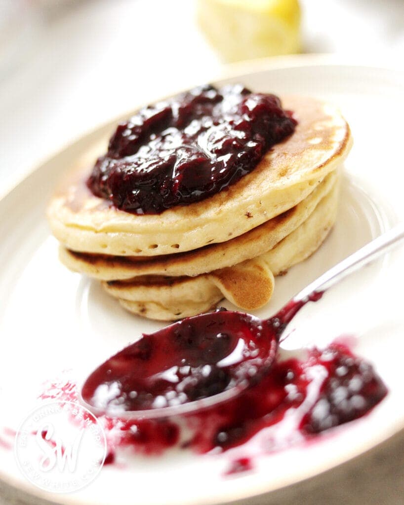 mixed berry compote smeared over a stack of buttermilk pancakes