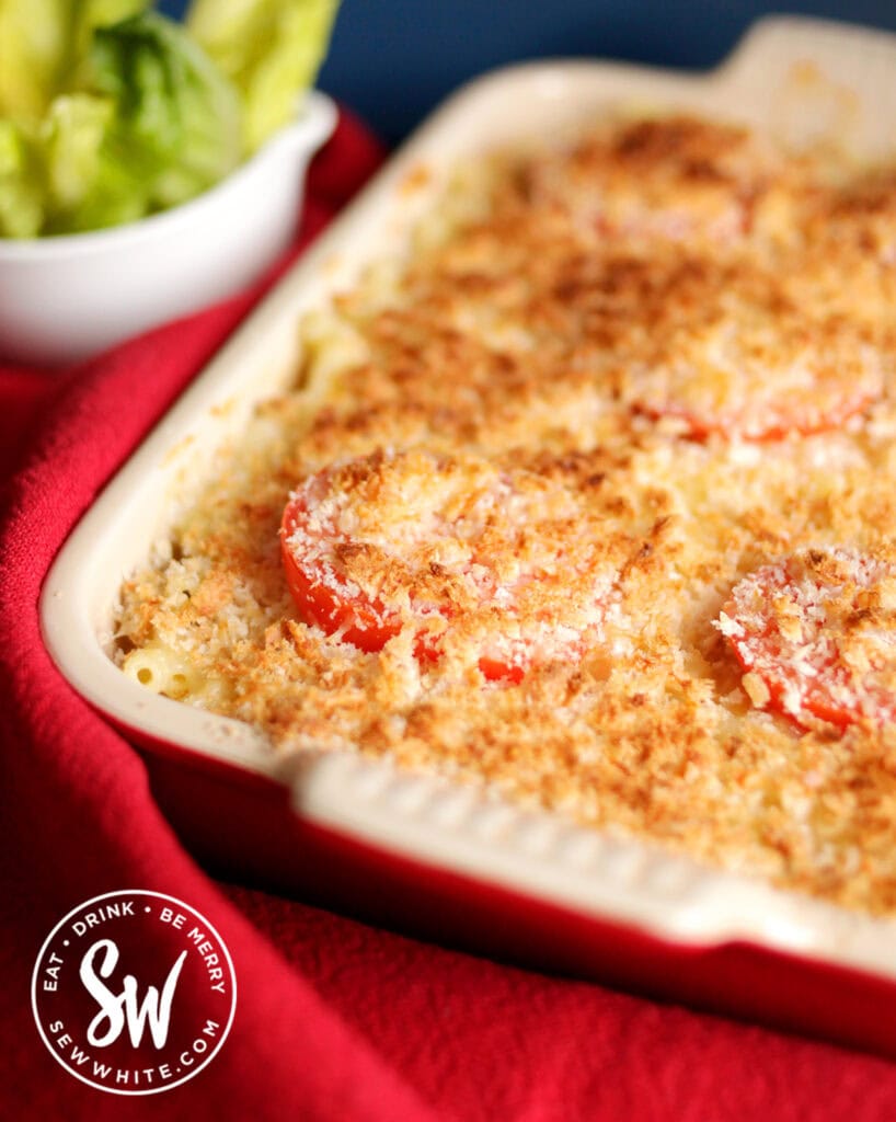 Creamy baked mac and cheese recipe with bread crumbs on top and slices of tomatoes