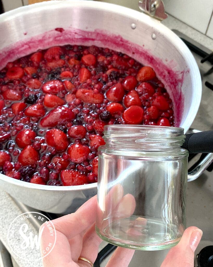 jam bubbling in a jam pan and jam jar