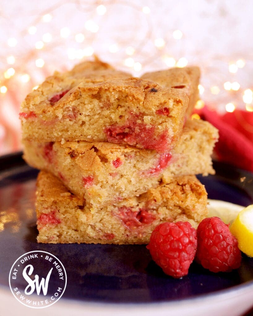 a golden brown stack of raspberry lemon blondies on a blue plate